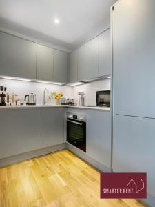 伊顿Eton, Windsor - 1 Bedroom First Floor Apartment - With Parking的厨房铺有木地板,配有白色橱柜。