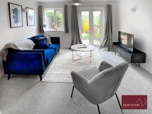 BrookwoodKnaphill, Woking - 2 Bedroom House - Garden and Parking的客厅配有蓝色的沙发和椅子