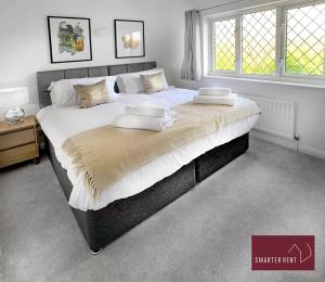 BrookwoodKnaphill, Woking - 2 Bedroom House - Garden and Parking的一张配有白色床单和枕头的大床