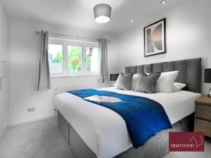 BisleyWest End, Woking - 2 Bed House With Parking and Garden的一间卧室设有一张大床和一个窗户。
