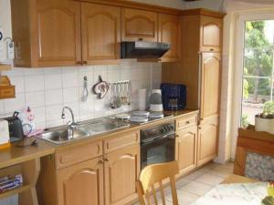 乌姆基希Villa Roder的厨房配有木制橱柜、水槽和炉灶。