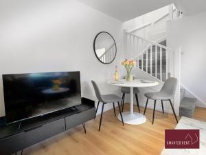 沃金厄姆Wokingham - 2 Bed Modern House - Parking的一间带桌子和大电视的用餐室
