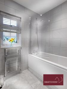 沃金厄姆Wokingham - 2 Bed Modern House - Parking的白色的浴室设有浴缸和窗户。