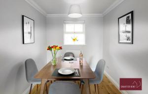 沃金厄姆Wokingham - 2 Bedroom Ground Floor Flat - With Parking的一间带木桌和椅子的用餐室