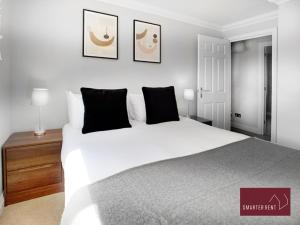 沃金厄姆Wokingham - 2 Bedroom Ground Floor Flat - With Parking的卧室配有一张带黑色枕头的大型白色床。