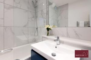 多尔金Dorking - Brand New 1 Bedroom Apartment的白色的浴室设有水槽和浴缸。