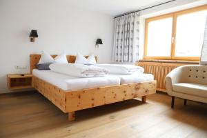 乌姆豪森Der Steinadler的一间卧室配有带白色枕头的木床
