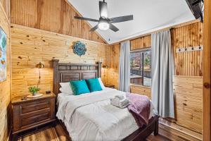 鸽子谷The Family Stone Luxe Cabin Sleeps 12 Hot tub Dogfriendly Dollywood的一间卧室配有一张床和吊扇