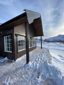KvalsundHytte i Neverfjord.的一座小建筑,地面上积雪