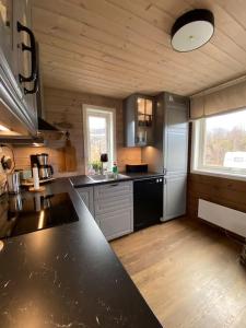 KvalsundHytte i Neverfjord.的一间厨房,里面设有黑色台面