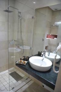 拉巴特Aralia Boutique Hôtel的一间带两个盥洗盆和淋浴的浴室