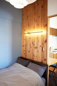 东京Shibuya apartment SHINSEN的一间卧室设有一张床和木墙