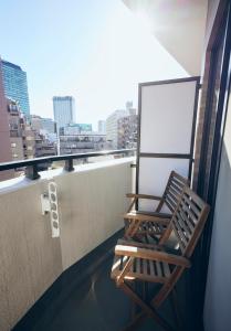 东京Shibuya apartment SHINSEN的市景阳台的椅子