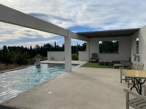 佩里阿克海Le Carignan的一个带桌子的游泳池和一个庭院