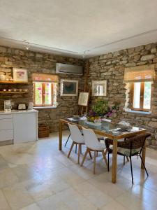 Agia TheodotiThe Artists House - Atelier Suite的厨房配有桌椅和石墙