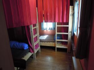 轻井泽Bellscabin Guesthouse的客房设有两张双层床和红色窗帘。