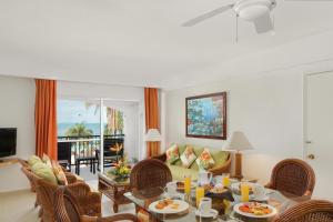 坎昆金哈海滨风景别墅&套房酒店的客厅配有桌椅