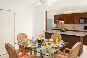 坎昆金哈海滨风景别墅&套房酒店的一间带桌椅的用餐室和一间厨房