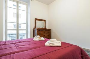 斯培西亚Casa Shakespeare的一间卧室配有一张紫色床和毛巾