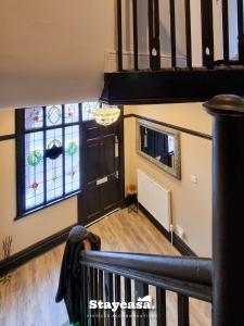 曼彻斯特Spacious 6br Home W Patio Free Parking!的客房设有楼梯和彩色玻璃窗。