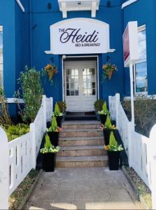 绍斯波特The Heidi Bed & Breakfast的蓝色的建筑,设有通往Halliki餐厅的楼梯