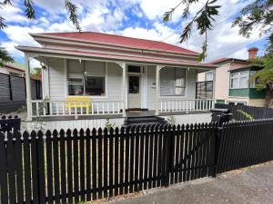 奥克兰Eden Park House Auckland的前面有栅栏的白色房子