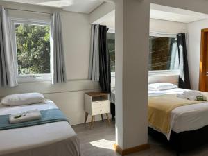 卡内拉Hotel Golden Hills的带2扇窗户的客房内的2张床