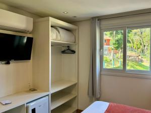 卡内拉Hotel Golden Hills的一间卧室配有电视、窗户和床。