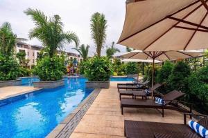 下龙湾Royal Lotus Hạ Long Resort - kiko resort的一个带椅子和遮阳伞的游泳池