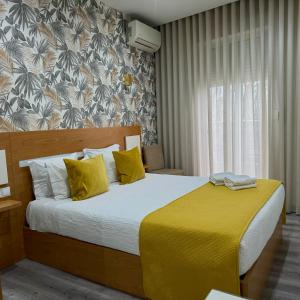 波尔图GuestHouse Marquês的一间卧室配有一张带黄色毯子的大床