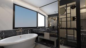 雅典Esse Athens的一间带大浴缸和大窗户的浴室