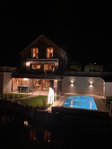 BettelChalets Petry Spa & Relax的一座晚上设有游泳池的房子