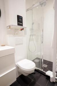 布洛涅-比扬古Villa Escudier Appart-hôtel的白色的浴室设有卫生间和淋浴。