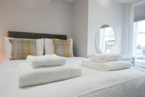 布伦特伍德Modern,central 1 bedroom flat的一张白色的床,上面有四个枕头