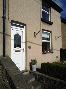 LlangoedEscape to Anglesey, Dog Friendly的白色门和两扇窗户的房子