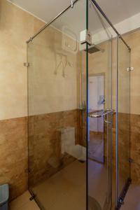博卡拉Purna的浴室里设有玻璃门淋浴