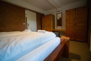 布尔格Hotel Kolonieschänke的一间卧室配有一张白色大床和木柜