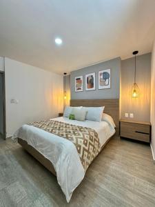 布卡拉曼加美景酒店的一间卧室配有一张大床,墙上有两张照片