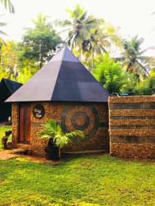 达瓦拉维Atha Safari Resort & Riverside Camping的一座有黑色屋顶的建筑,上面有标志