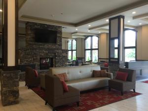 塔科马西雅图塔科马品质套房酒店的大堂配有沙发、椅子和壁炉