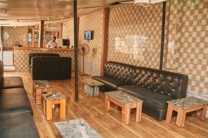 阿布贾GLAMOUR PARK'S HOTEL, ABUJA的客厅配有黑色真皮沙发和桌子