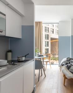 伦敦莱蒙洛克公寓式酒店的一间厨房,配有白色橱柜和一间餐厅