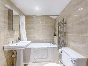 奇彭纳姆3 Bed in Chippenham 77334的一间带水槽、浴缸和卫生间的浴室