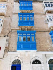 弗洛里亚纳San Francisco Studios Valletta的建筑的侧面设有蓝色窗户