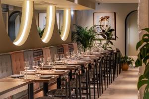 波尔图Laranjais Boutique Suites & Apartments Porto的餐厅的一张长排桌子,灯火通明