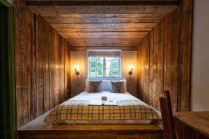 Saint Mary Bourne伯恩谷酒店 的卧室配有木墙内的一张床