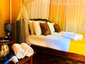 达瓦拉维Atha Safari Resort & Riverside Camping的一间卧室配有带毛巾的床