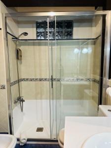 利亚内斯Casa Conce Zona de playa y montaña的一间带卫生间的浴室内的玻璃淋浴间