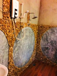 达瓦拉维Atha Safari Resort & Riverside Camping的浴室设有石墙和3个淋浴喷头