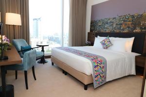 科伦坡Sofia Colombo City Hotel的酒店客房配有一张床、一张桌子和一把椅子。
